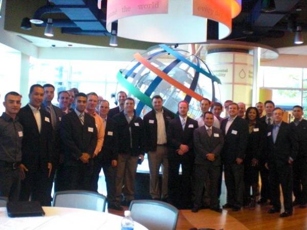 group of attendees pose for photo in front of globe