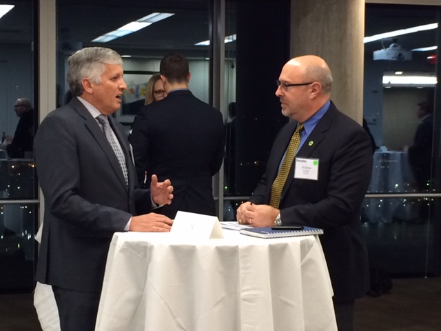 two men standing at a high table talking