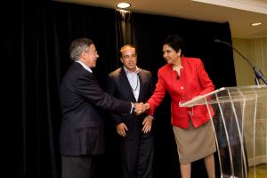 Sid Goodfriend and  Indra K. Nooyi, shake hands as someone else looks on