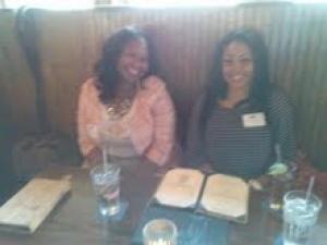 two women sitting at a table smiling at the camera