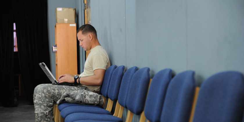 Soldier typing on laptop