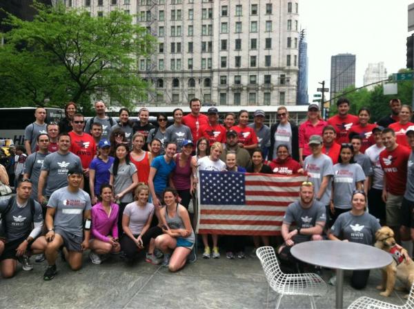 Group photo of Team Red, White and Blue and Team Rubicon - holding the American Flag
