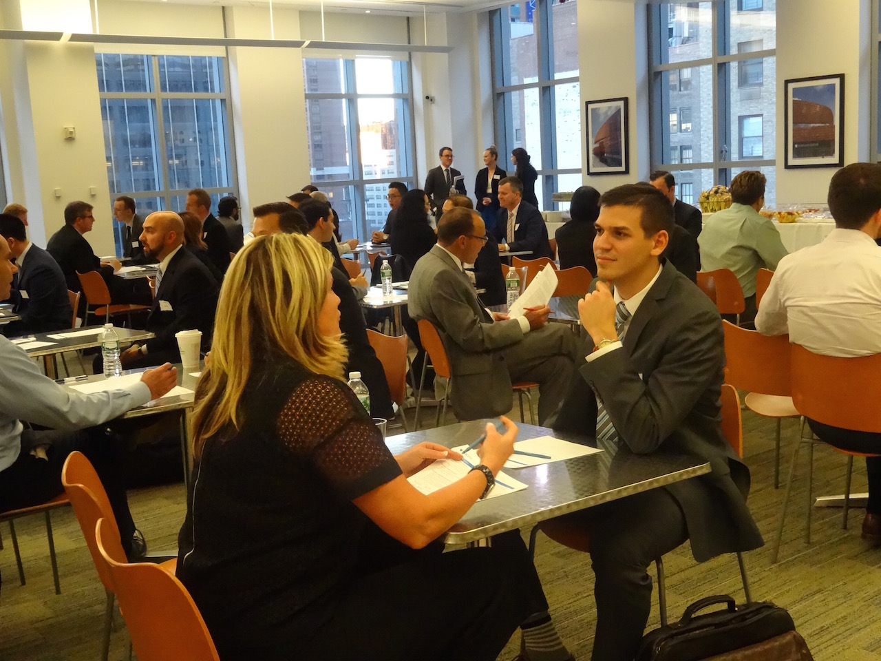 A woman and a Man sitting at a table talking and looking at papers