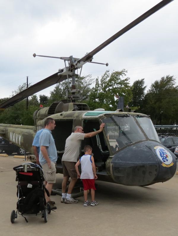 3 men and a young boy checking out a helicopter