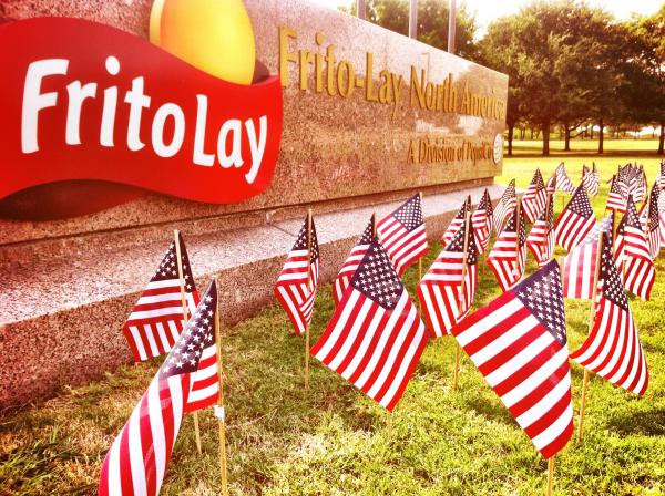 American flags planted in front of Frito Lay Headquarters sign