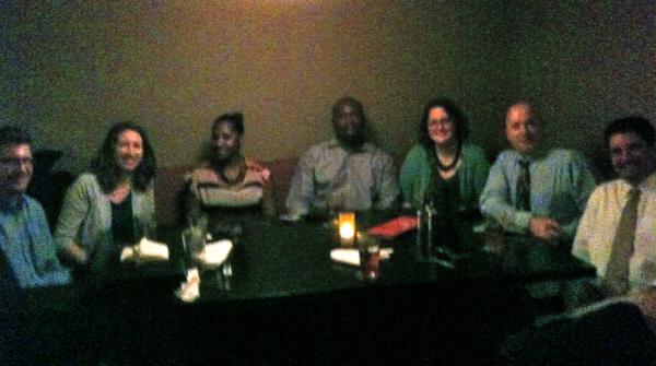 7 people pose for photo sitting at a table in the Tap House Grille