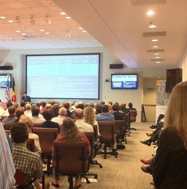 Attendees sitting in auditorium listening to speaker