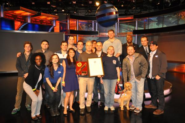 Group photo of some of the participants with Jon Stewart - Jon is holding the gifts he was given