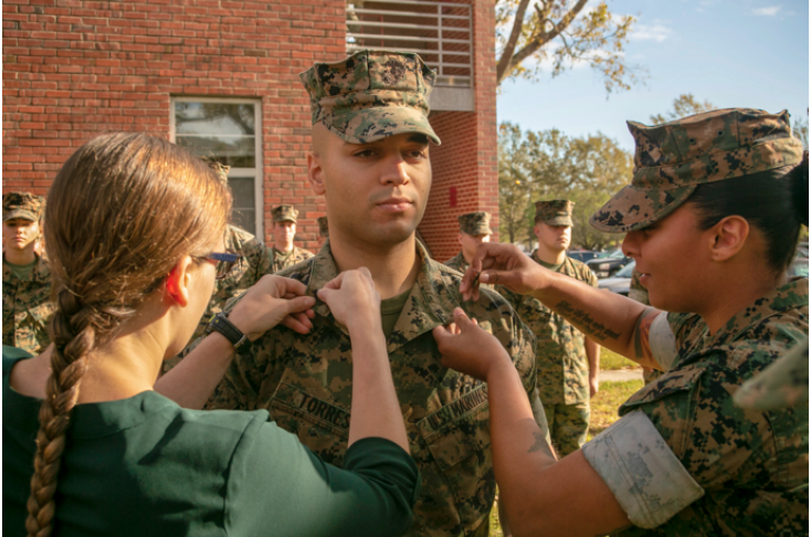 Raul Torres’ wife Caitlin (left) and Staff Sergeant Gabby Petticrew (right) pin Sergeant chevrons on Raul’s collar during his promotion ceremony in Camp Lejeune, North Carolina.