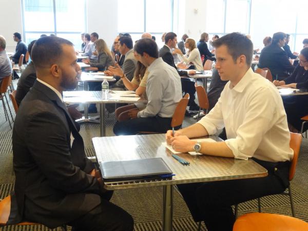 2 men sitting at a table facing each other